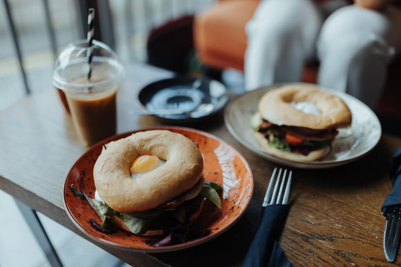 Coffee and breakfast bagels on a café table