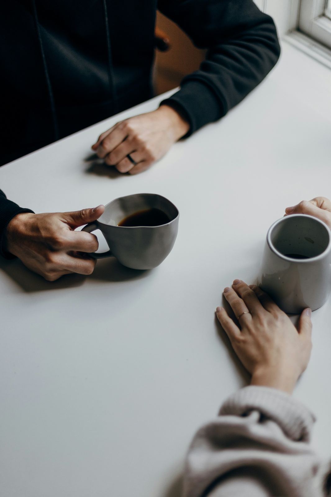 Two people sharing coffee across a table