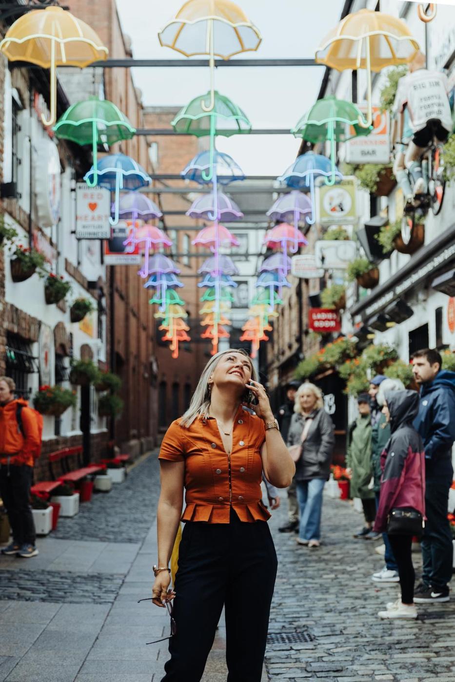 Maria Morgan on a call beneath the umbrella lights in Belfast city centre